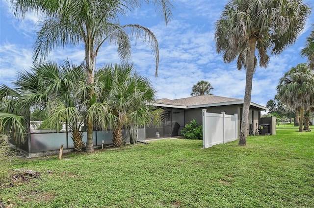 view of yard with a lanai and fence