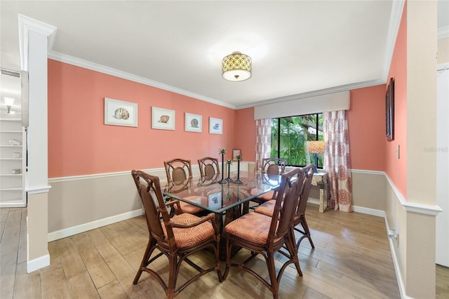 dining area with light hardwood / wood-style flooring and ornamental molding