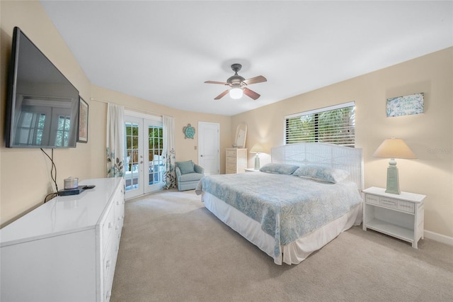 bedroom featuring ceiling fan, light colored carpet, multiple windows, and french doors