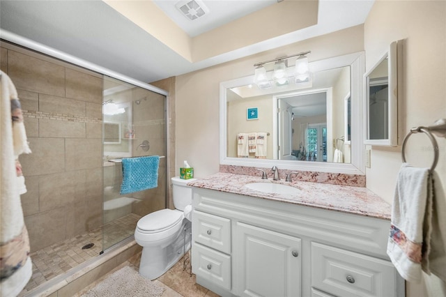 bathroom featuring tile patterned flooring, vanity, toilet, and a shower with door