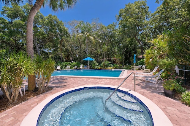 view of swimming pool with a patio and a hot tub