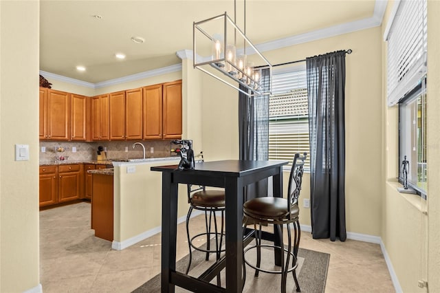 kitchen with pendant lighting, a kitchen breakfast bar, backsplash, and a notable chandelier