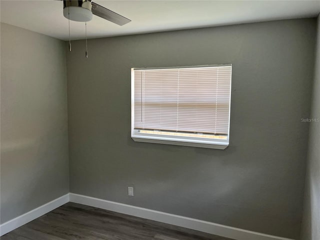 empty room with ceiling fan and dark hardwood / wood-style flooring