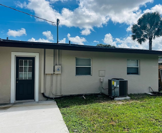 exterior space with cooling unit and a lawn