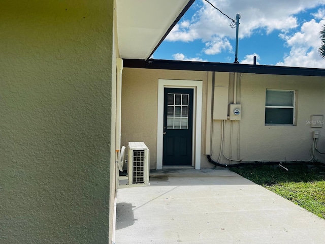 view of exterior entry with a patio