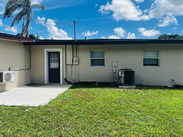 rear view of property with ac unit, a yard, and central AC unit