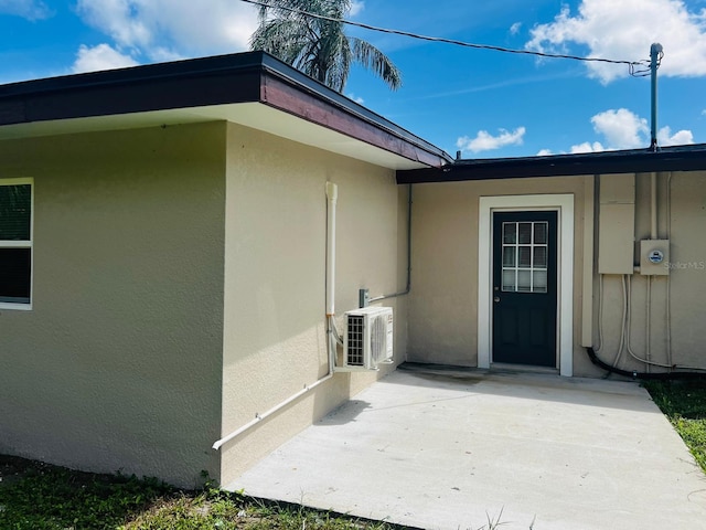 doorway to property featuring ac unit and a patio area