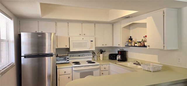 kitchen featuring white appliances, sink, and white cabinets