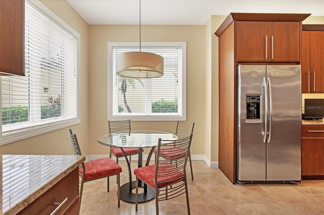 kitchen with a healthy amount of sunlight, decorative light fixtures, and stainless steel fridge with ice dispenser