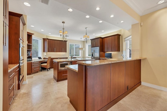 kitchen with built in desk, kitchen peninsula, hanging light fixtures, a kitchen island, and stainless steel appliances