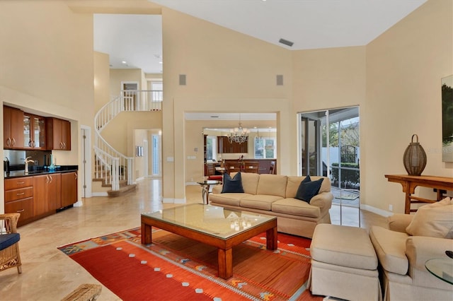 living room featuring a towering ceiling, a chandelier, and sink