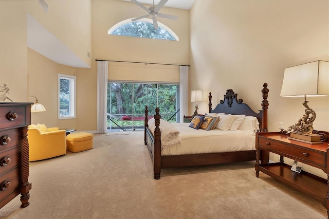 carpeted bedroom featuring a high ceiling, ceiling fan, and access to exterior