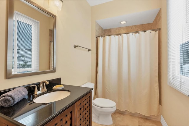 bathroom featuring curtained shower, vanity, toilet, and a wealth of natural light