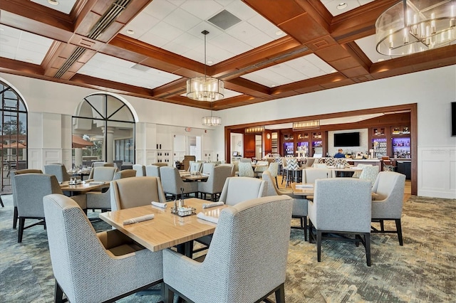 dining room with a notable chandelier, beamed ceiling, and coffered ceiling