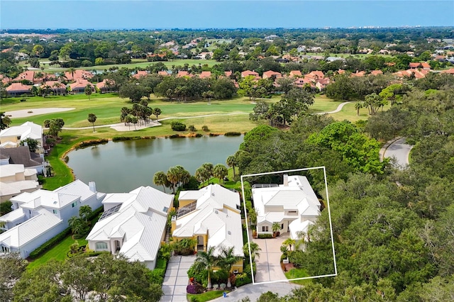 drone / aerial view featuring a residential view, view of golf course, and a water view