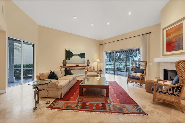 living room with a towering ceiling and a fireplace