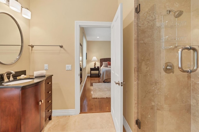 full bathroom with connected bathroom, a shower stall, baseboards, and vanity