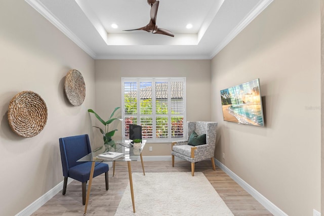 sitting room featuring a tray ceiling, ceiling fan, light hardwood / wood-style floors, and ornamental molding