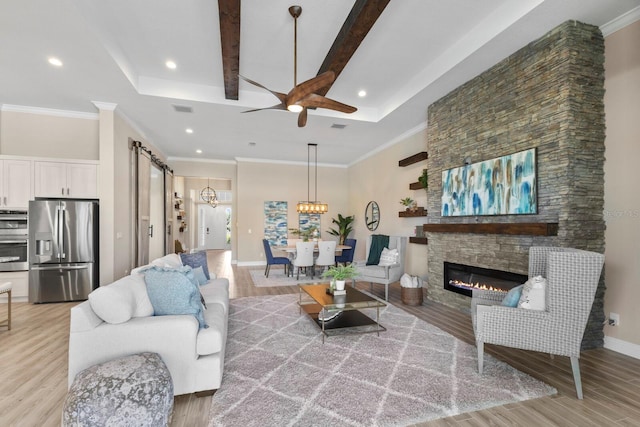 living room with hardwood / wood-style floors, a fireplace, beam ceiling, and ornamental molding