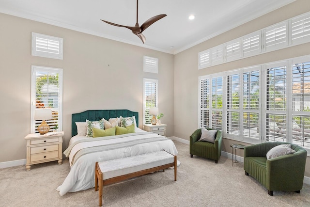 carpeted bedroom featuring ornamental molding, ceiling fan, and a high ceiling