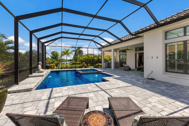 view of pool with a patio, ceiling fan, glass enclosure, and an in ground hot tub