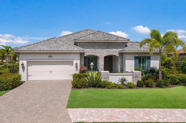 mediterranean / spanish home with a garage and a front lawn