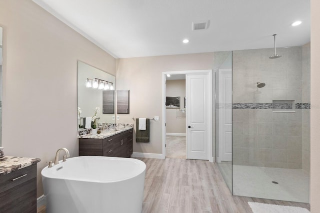 bathroom with shower with separate bathtub, vanity, and hardwood / wood-style flooring