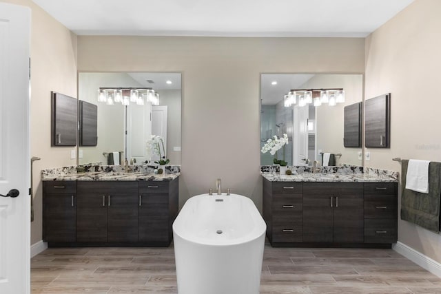 bathroom featuring a tub to relax in, vanity, and wood-type flooring