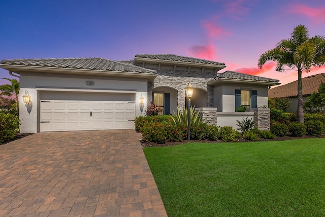 mediterranean / spanish house with a garage and a yard