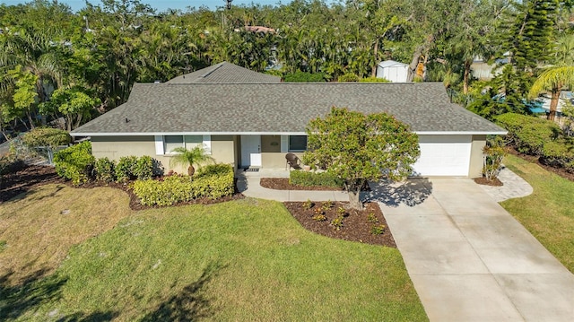 view of front of house featuring a garage, a shed, and a front lawn