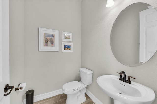 bathroom featuring toilet, hardwood / wood-style flooring, and sink