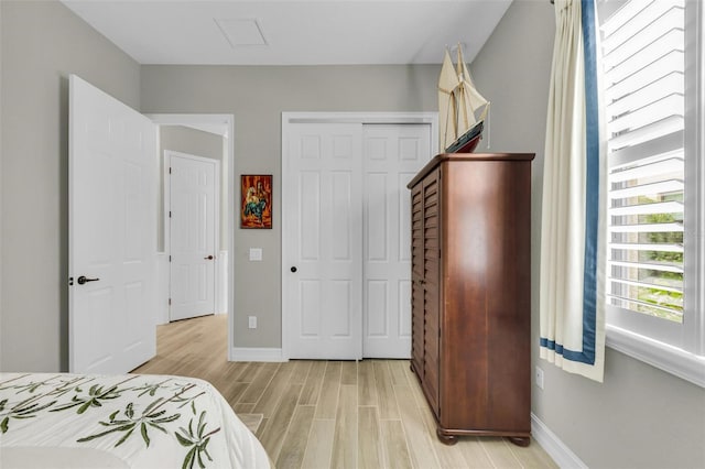 bedroom with light wood-type flooring and a closet