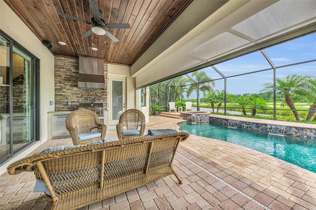 view of swimming pool featuring a grill, a lanai, a patio, pool water feature, and ceiling fan