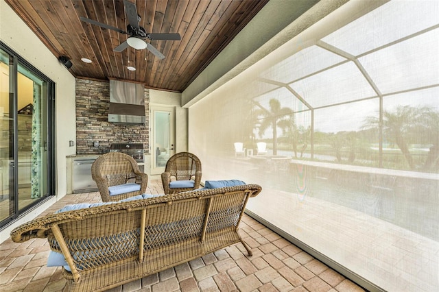 sunroom featuring wood ceiling and ceiling fan