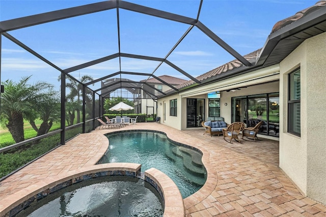 view of pool with a lanai, an in ground hot tub, and a patio