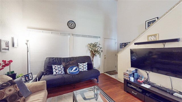 living room featuring wood-type flooring and a towering ceiling