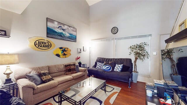 living room featuring dark wood-type flooring and high vaulted ceiling