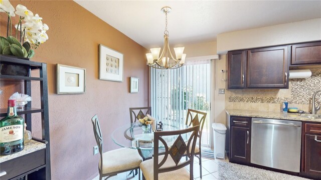 dining room featuring an inviting chandelier, sink, and light tile patterned floors