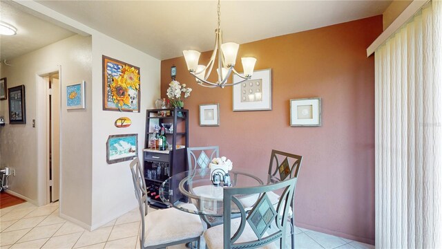 tiled dining area featuring an inviting chandelier