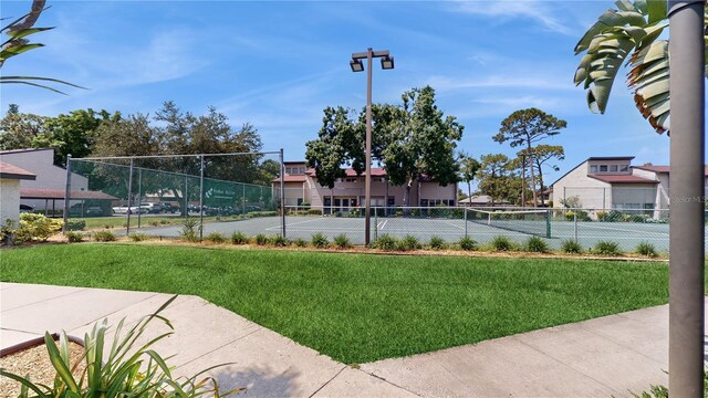 view of home's community with tennis court and a yard