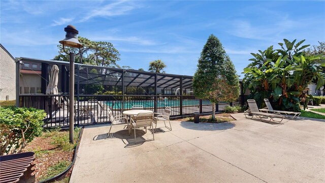 view of patio / terrace featuring a lanai and a community pool