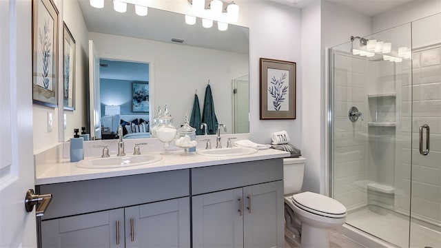 bathroom featuring vanity, toilet, and a shower with shower door