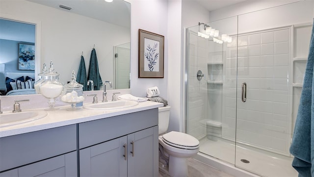 bathroom featuring vanity, toilet, and a shower with shower door