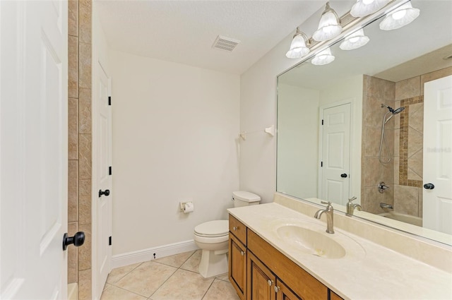 full bathroom with tile patterned flooring, tiled shower / bath combo, toilet, vanity, and a textured ceiling