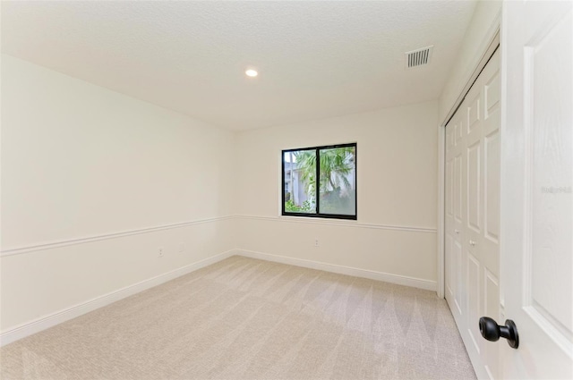 spare room featuring light colored carpet