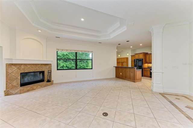 unfurnished living room featuring a raised ceiling, a fireplace, light tile patterned flooring, and crown molding