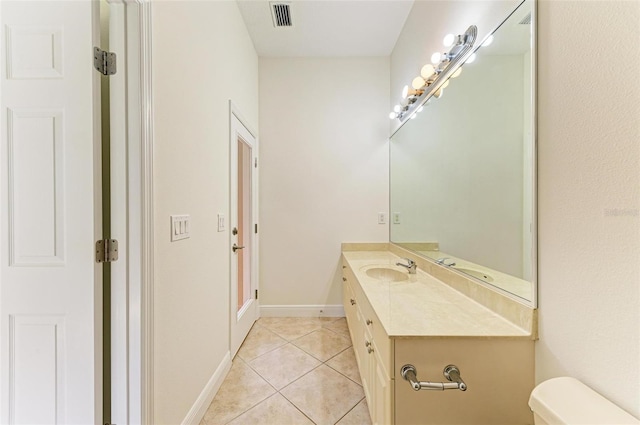 bathroom with toilet, tile patterned floors, and vanity