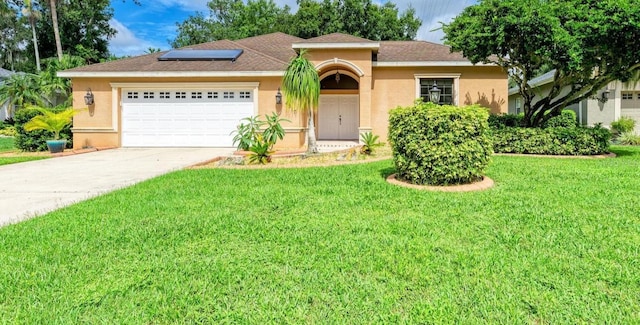 view of front of house with a garage, a front lawn, and solar panels