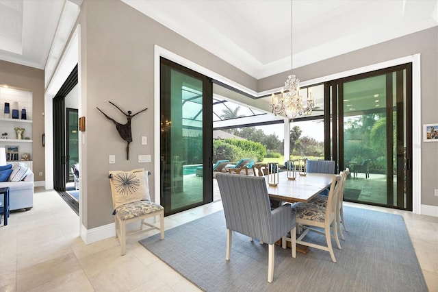 dining area with a raised ceiling, a wealth of natural light, and a chandelier