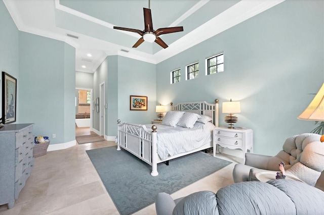 bedroom featuring ceiling fan, a high ceiling, connected bathroom, and crown molding